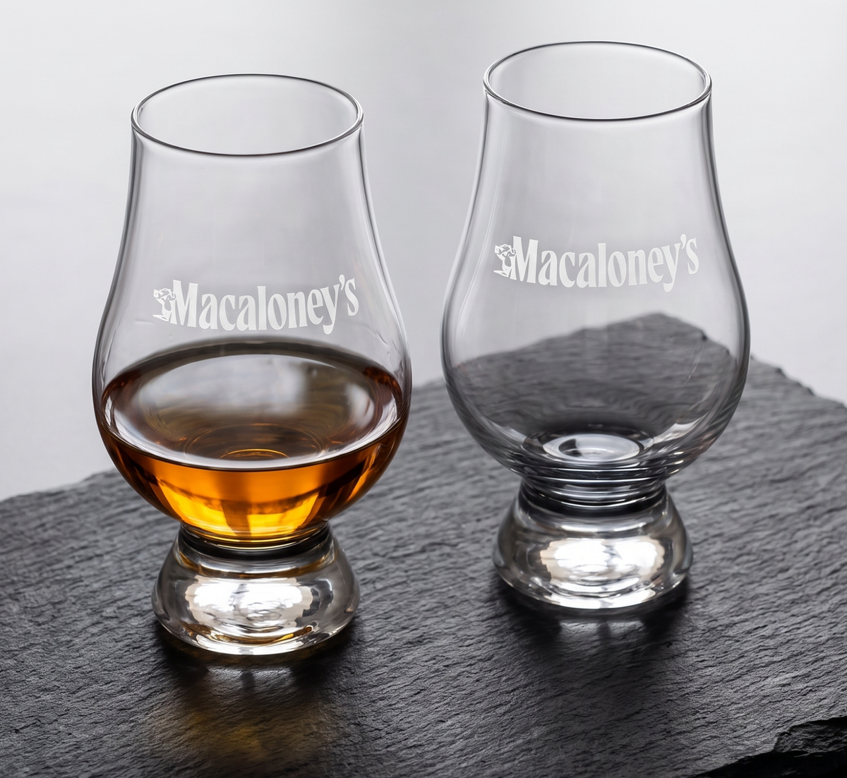 Two Macaloney's etched Glencairn glasses on slate