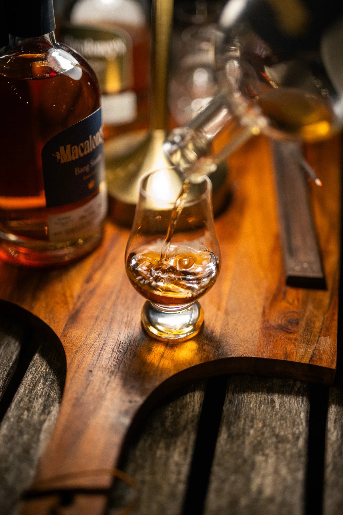 Bang Sauce poured into a Glencairn glass on a wooden tasting board