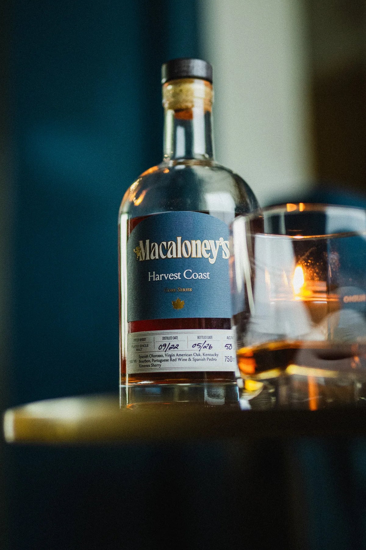 Harvest Coast bottle on a gold table with a poured whisky