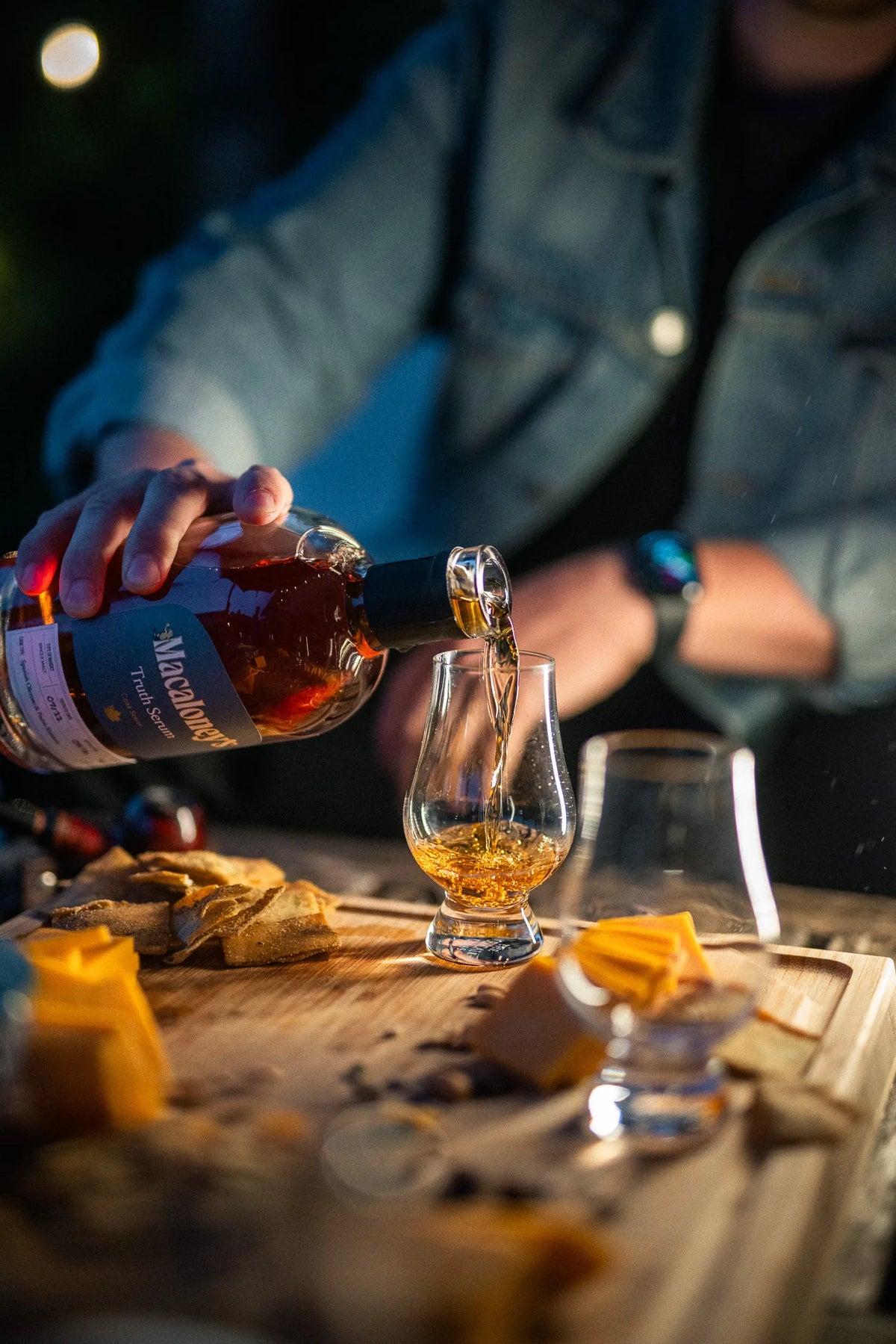 Truth Serum poured into a Glencairn glass at an evening gathering